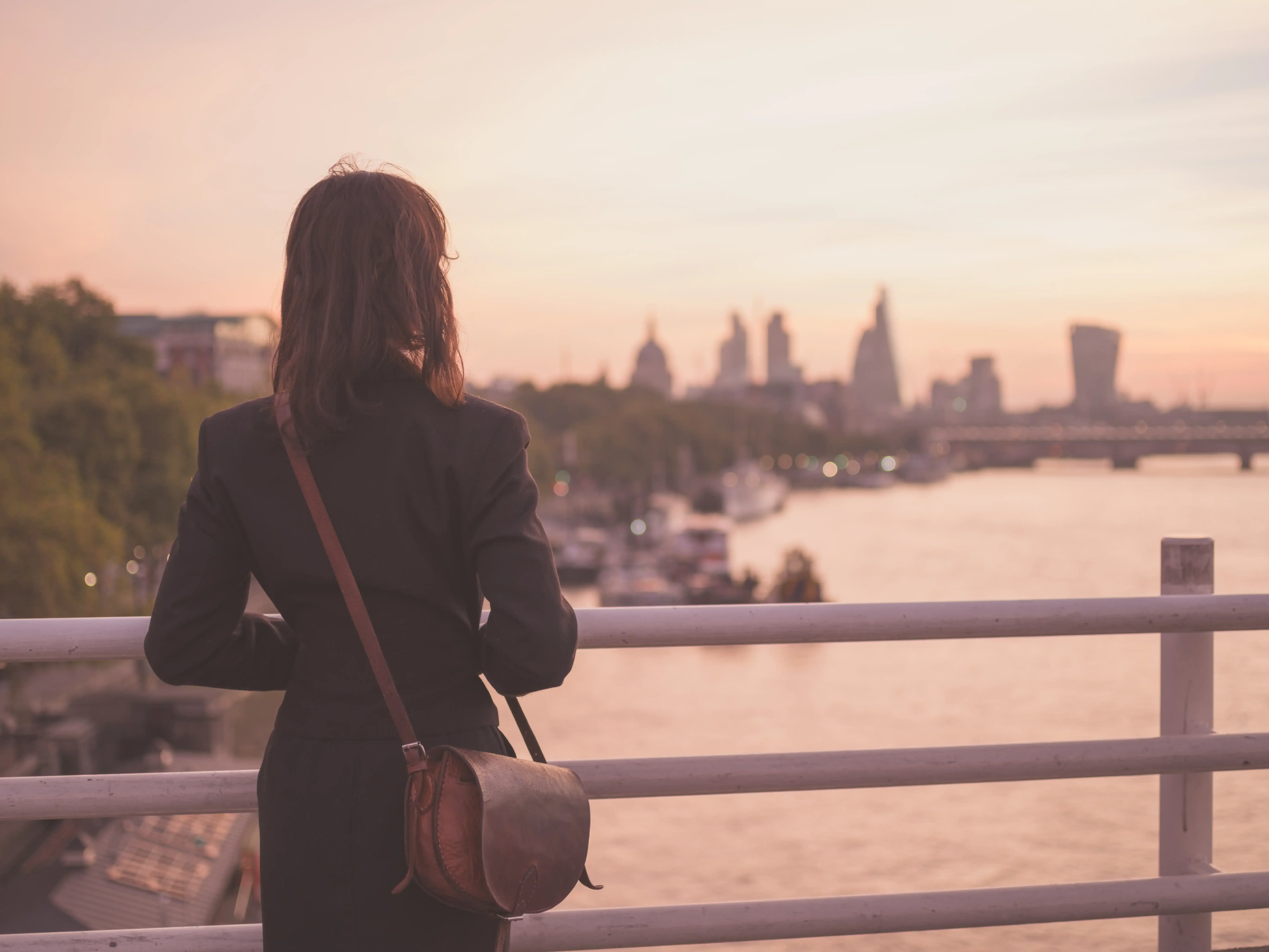 Donna che guarda il fiume al tramonto