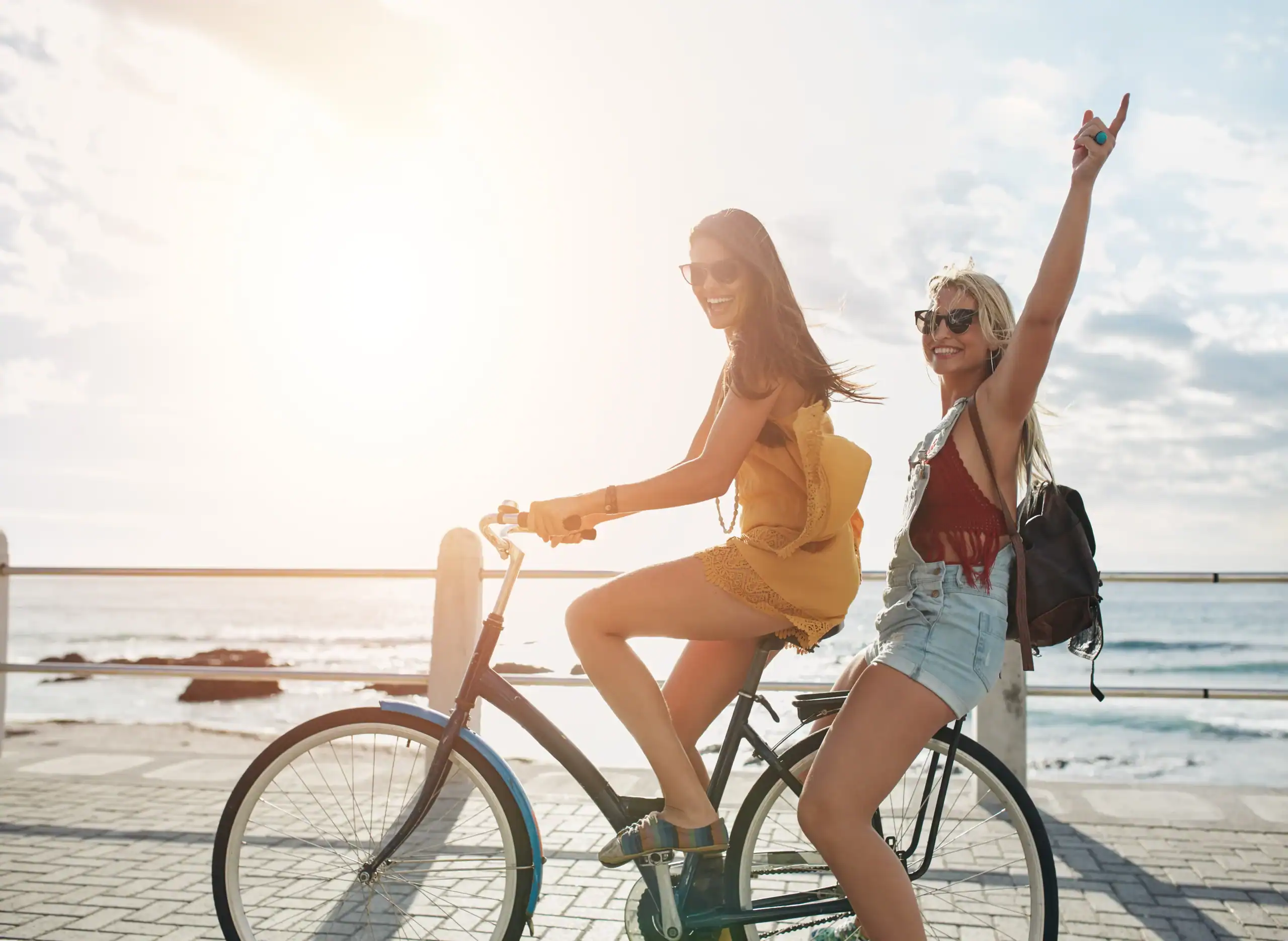 Due ragazze in bicicletta al tramonto.