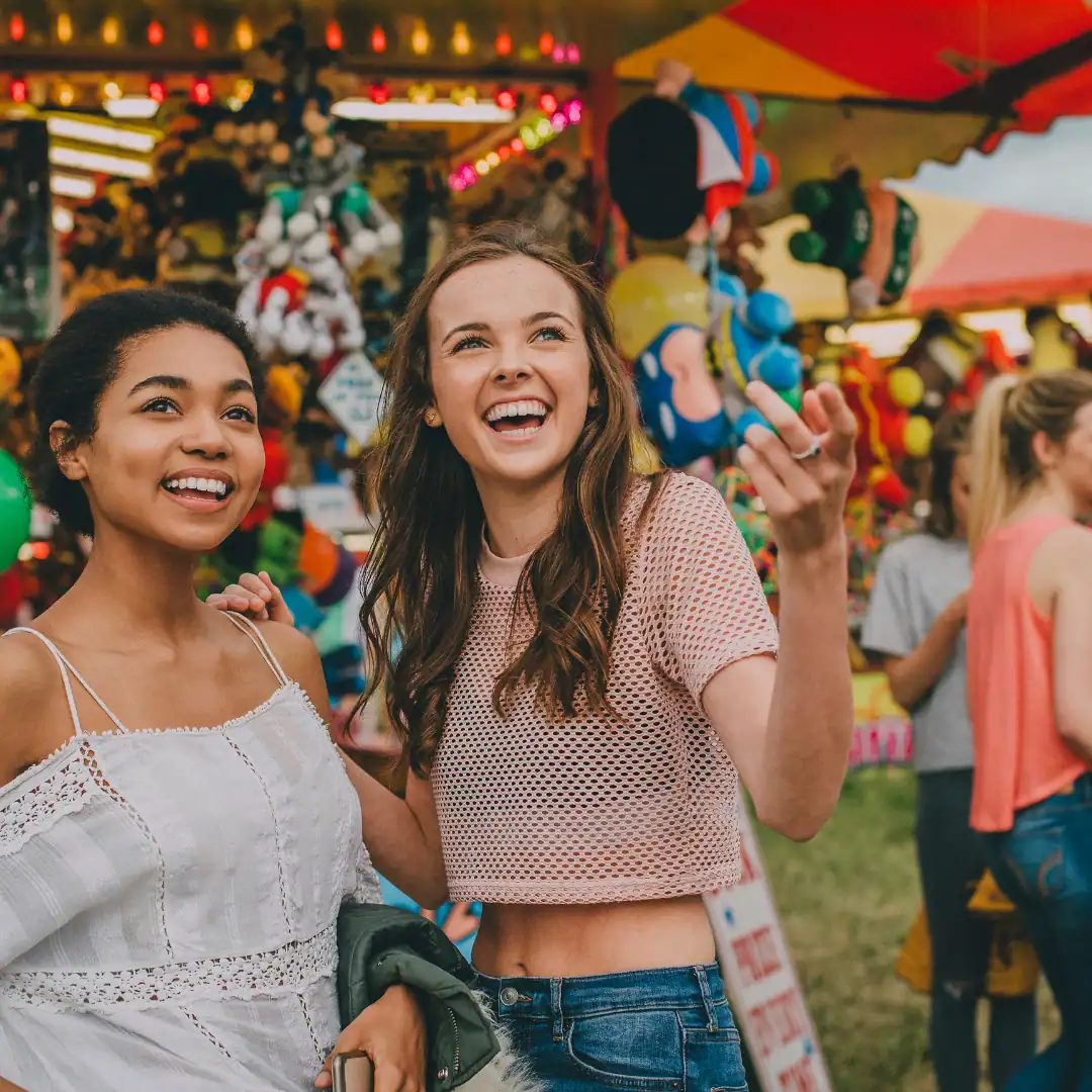 Due ragazze sorridenti a una fiera.