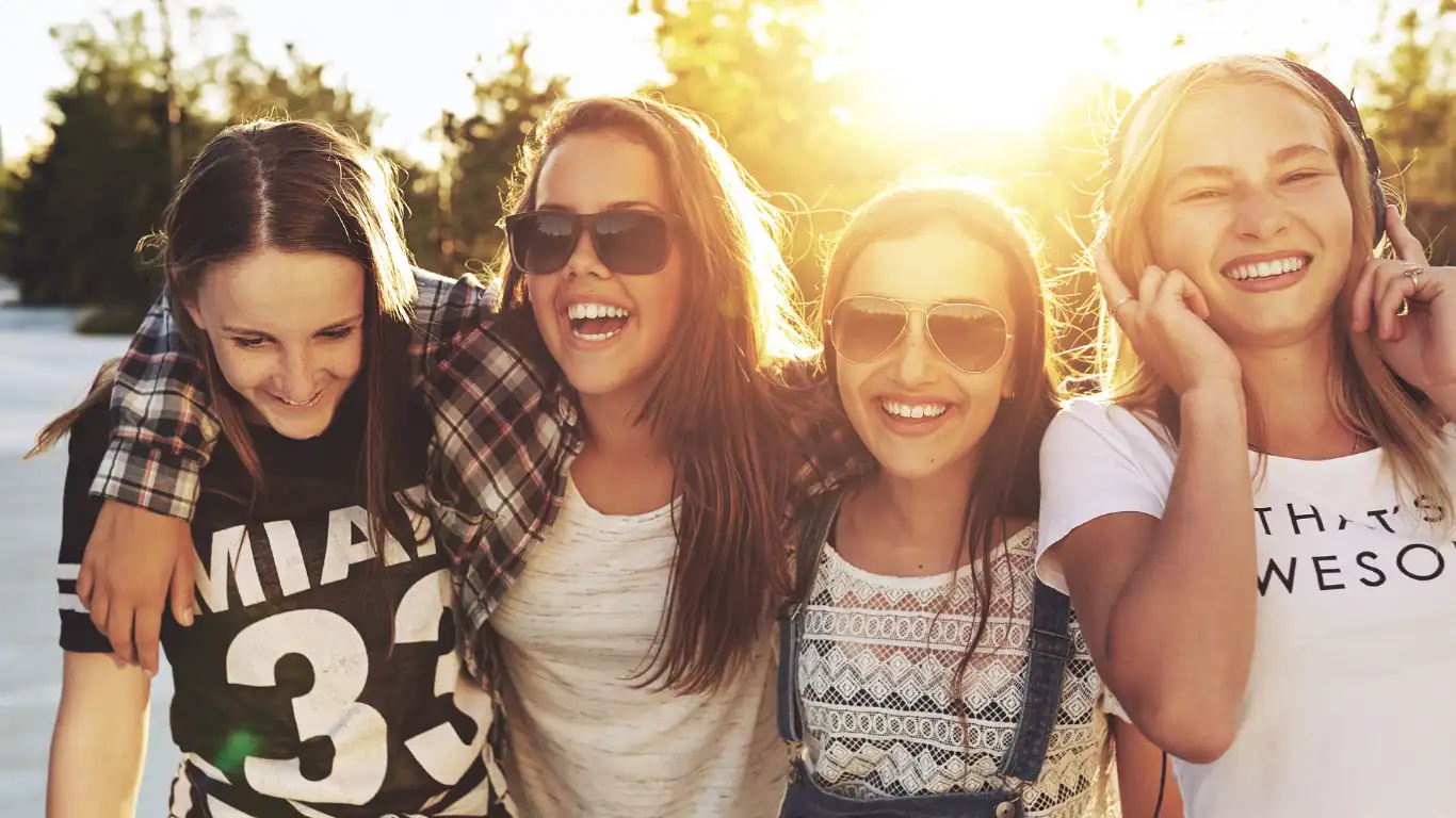 Amiche sorridenti al tramonto.