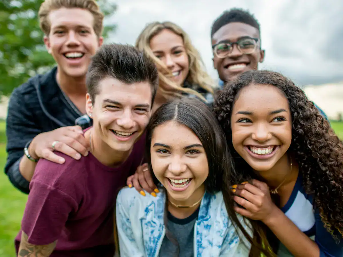 Gruppo di amici sorridenti all'aperto.