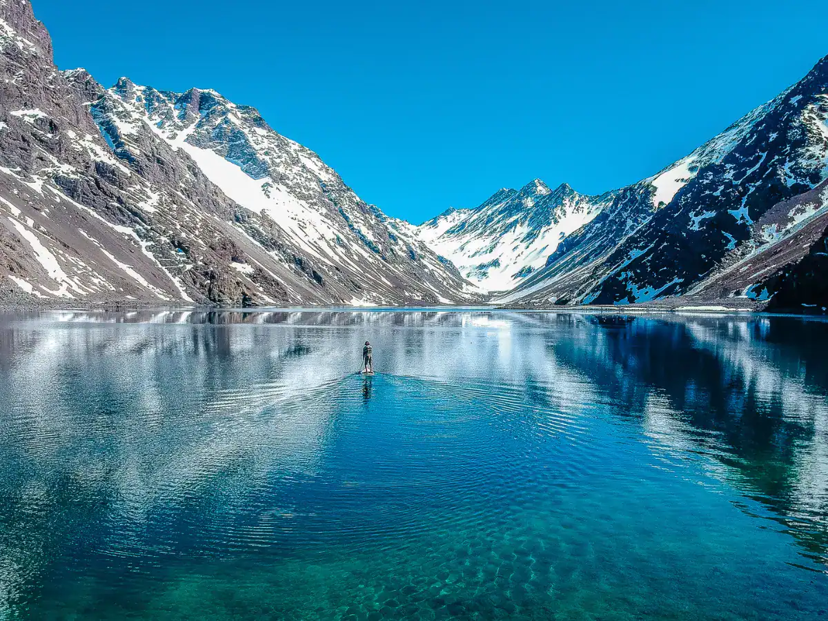 Lago tranquillo con montagne innevate.