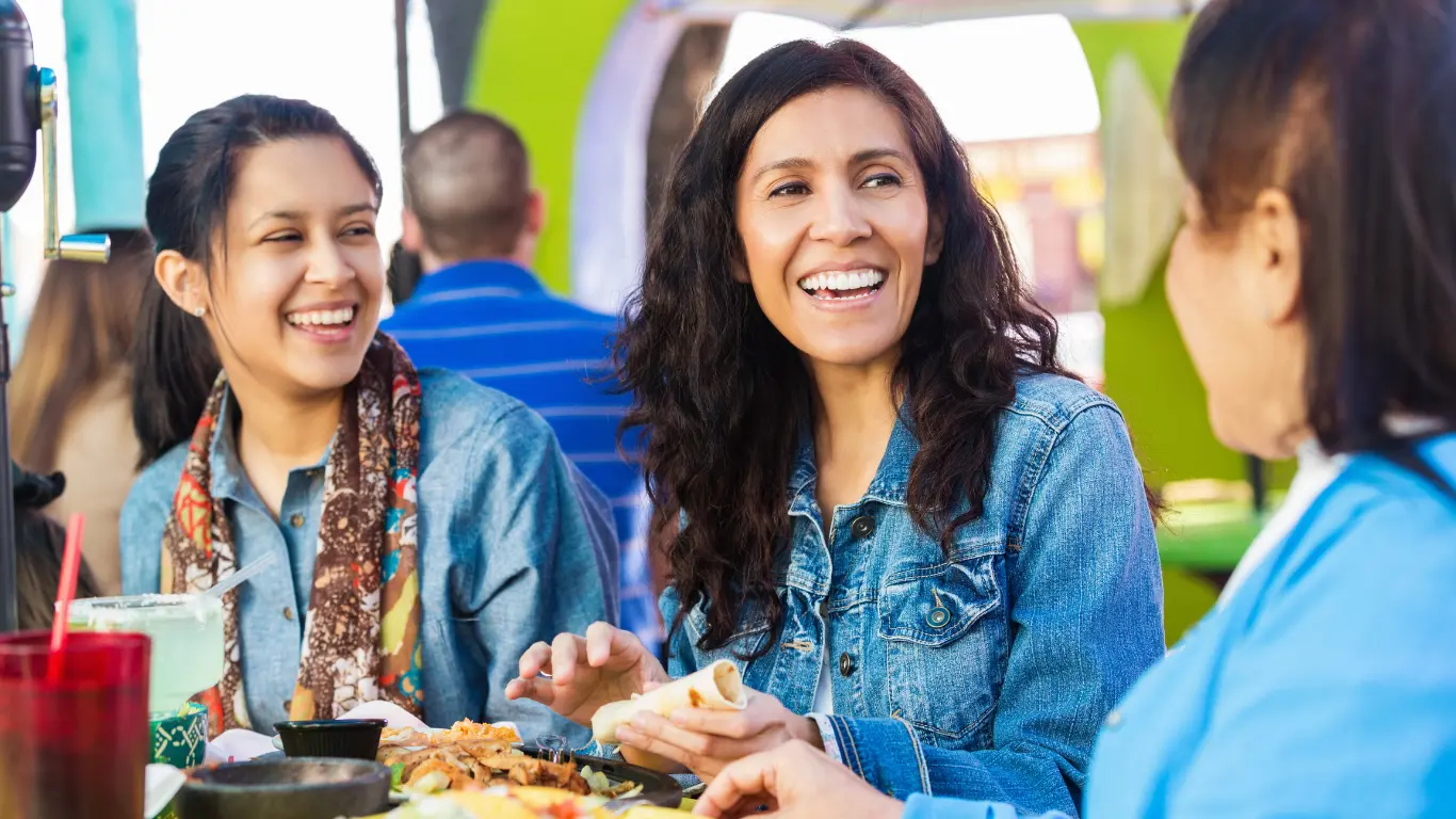 3 donne che sorridono mentre pranzano
